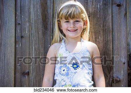 Smiling Caucasian girl posing at wooden fence View Large Photo Image Stock Photograph - Smiling Caucasian girl posing at wooden fence. Fotosearch
