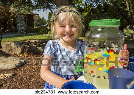 Stock Image - Smiling Caucasian girl posing with lemonade. Fotosearch