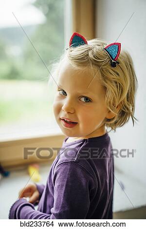 Picture - Smiling Caucasian girl wearing cat ears. Fotosearch
