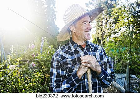 Smiling Caucasian man standing in garden View Large Photo Image Stock Image - Smiling Caucasian man standing in garden. Fotosearch