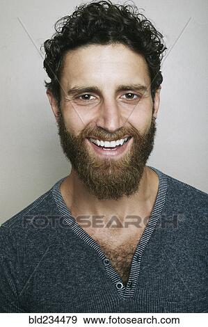 Stock Photo - Smiling Caucasian man with beard looking at camera. Fotosearch