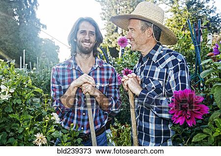 Smiling Caucasian men standing in garden View Large Photo Image Stock Image - Smiling Caucasian men standing in garden. Fotosearch