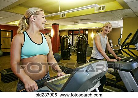 Smiling Caucasian mother and daughter on treadmills View Large Photo Image Stock Photography - Smiling Caucasian mother and daughter on treadmills. Fotosearch