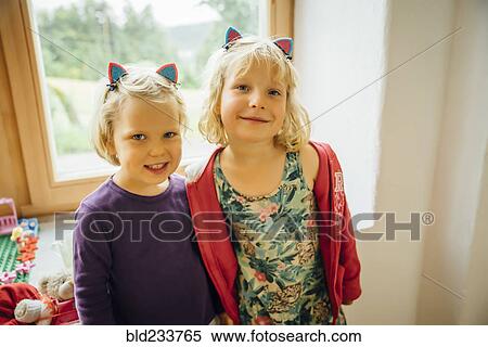 Smiling Caucasian sisters wearing cat ears View Large Photo Image Stock Photography - Smiling Caucasian sisters wearing cat ears. Fotosearch