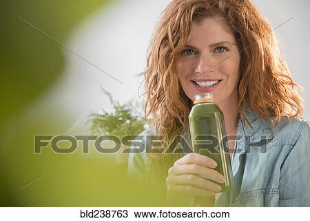 Smiling Caucasian woman drinking green smoothie View Large Photo Image Stock Image - Smiling Caucasian woman drinking green smoothie. Fotosearch