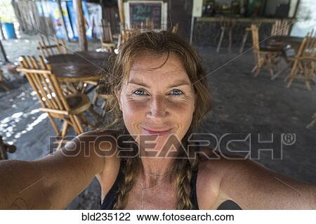 Stock Image - Smiling Caucasian woman posing for self-portrait. Fotosearch