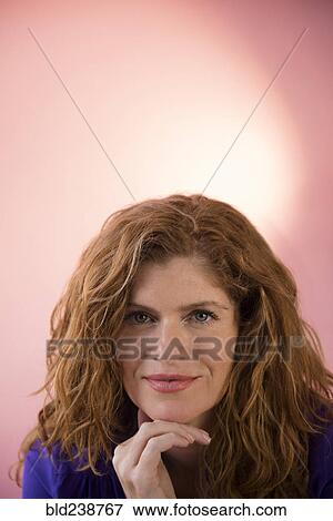 Stock Photo - Smiling Caucasian woman posing with hand on chin. Fotosearch