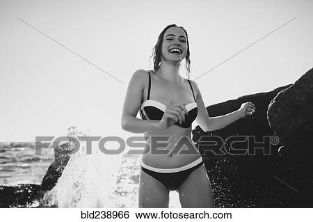 Smiling Caucasian woman standing on beach in bikini View Large Photo Image Stock Photograph - Smiling Caucasian woman standing on beach in bikini. Fotosearch