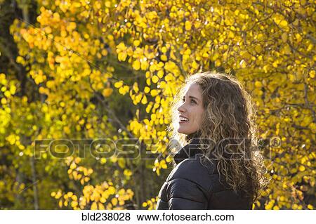 Smiling Caucasian woman under autumn leaves View Large Photo Image Stock Photo - Smiling Caucasian woman under autumn leaves. Fotosearch
