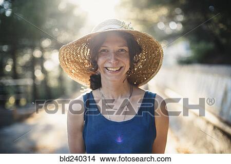 Picture - Smiling Caucasian woman wearing sun hat. Fotosearch