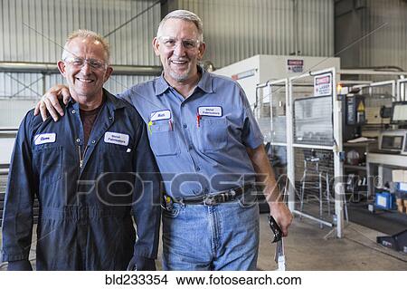 Smiling Caucasian workers posing in factory View Large Photo Image Picture - Smiling Caucasian workers posing in factory. Fotosearch
