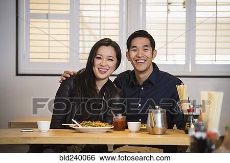 Smiling Chinese couple hugging in restaurant View Large Photo Image Stock Photograph - Smiling Chinese couple hugging in restaurant. Fotosearch