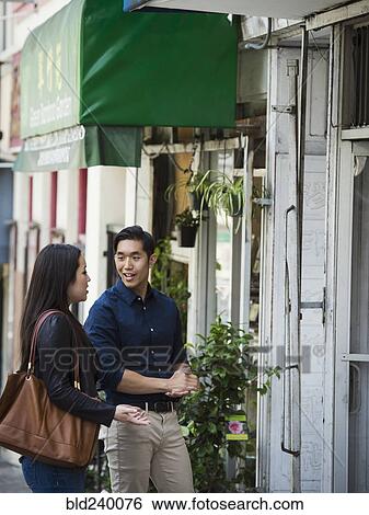 Stock Photograph - Smiling Chinese couple on city sidewalk. Fotosearch