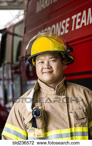 Smiling Chinese fireman standing near fire truck View Large Photo Image Stock Image - Smiling Chinese fireman standing near fire truck. Fotosearch