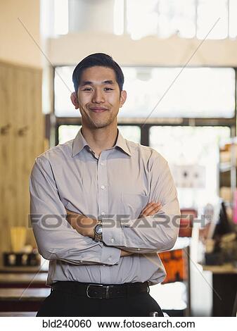 Stock Image - Smiling Chinese man posing in restaurant. Fotosearch