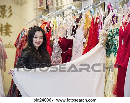 Smiling Chinese woman shopping for dress View Large Photo Image Stock Photo - Smiling Chinese woman shopping for dress. Fotosearch