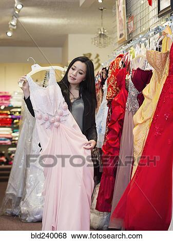 Smiling Chinese woman shopping for dress View Large Photo Image Stock Photo - Smiling Chinese woman shopping for dress. Fotosearch