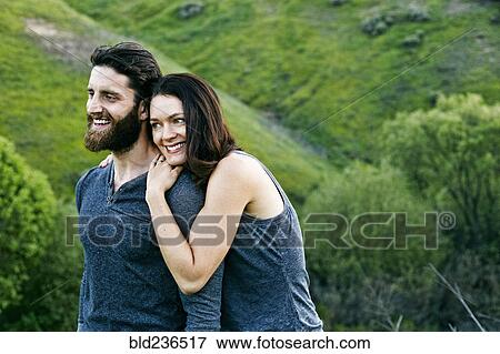 Smiling couple standing on hill View Large Photo Image Stock Photo - Smiling couple standing on hill. Fotosearch