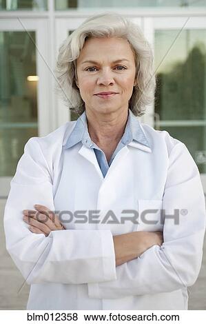 Stock Photo - Smiling doctor standing outdoors. Fotosearch