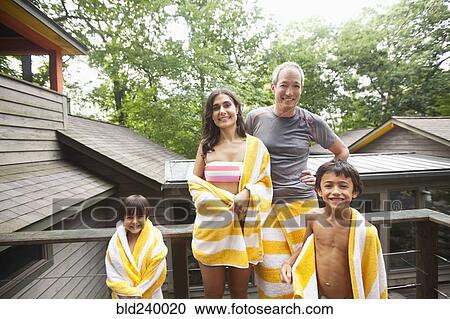 Stock Image - Smiling family wrapped in towels. Fotosearch