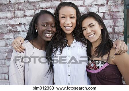 Stock Image - Smiling friends hugging. Fotosearch