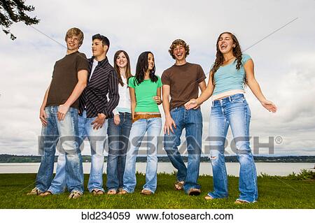Stock Photo - Smiling friends posing near river. Fotosearch