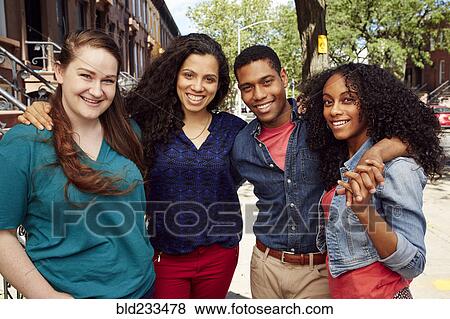 Stock Photo - Smiling friends posing on city sidewalk. Fotosearch