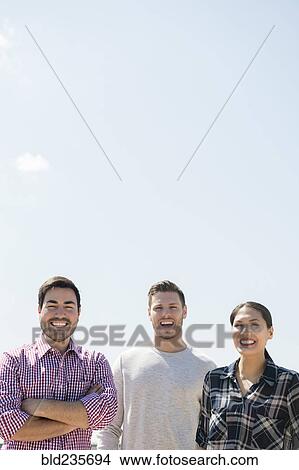 Picture - Smiling friends posing outdoors. Fotosearch