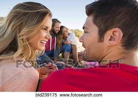 Smiling friends relaxing at beach View Large Photo Image Stock Photography - Smiling friends relaxing at beach. Fotosearch