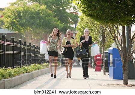 Stock Image - Smiling friends shopping together. Fotosearch