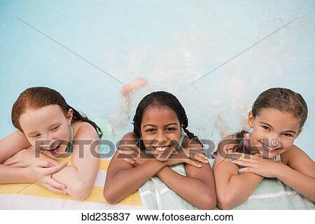 Smiling girls posing at the edge of swimming pool View Large Photo Image Stock Photo - Smiling girls posing at the edge of swimming pool. Fotosearch