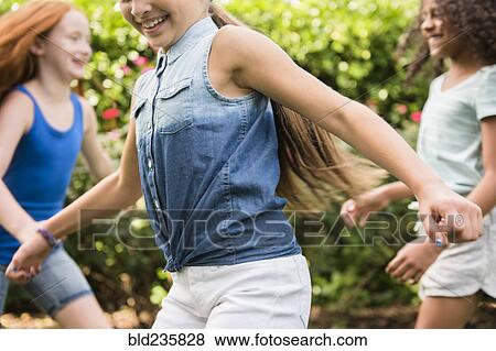 Stock Photo - Smiling girls running outdoors. Fotosearch