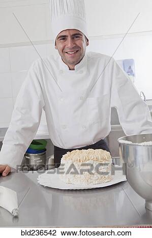 Smiling Hispanic chef posing with cake View Large Photo Image Stock Image - Smiling Hispanic chef posing with cake. Fotosearch