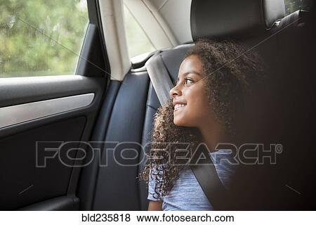 Smiling Hispanic girl in car looking out window View Large Photo Image Stock Photo - Smiling Hispanic girl in car looking out window. Fotosearch