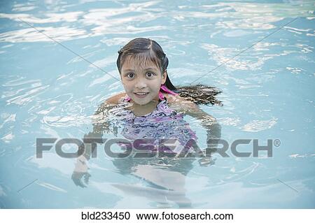 Stock Image - Smiling Hispanic girl in swimming pool. Fotosearch