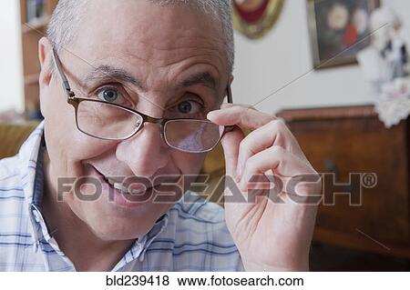 Smiling Hispanic man peering over eyeglasses View Large Photo Image Stock Photo - Smiling Hispanic man peering over eyeglasses. Fotosearch