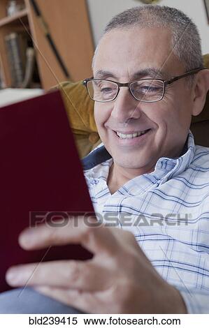 Smiling Hispanic man reading book View Large Photo Image Stock Photography - Smiling Hispanic man reading book. Fotosearch
