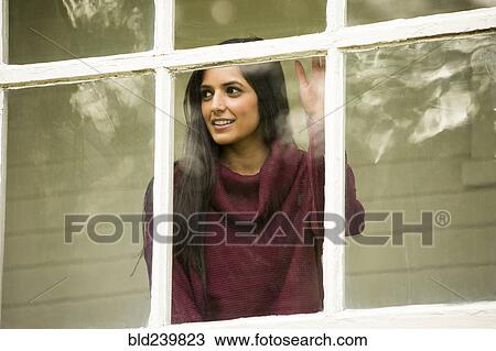 Smiling Indian woman leaning on window View Large Photo Image Stock Image - Smiling Indian woman leaning on window. Fotosearch