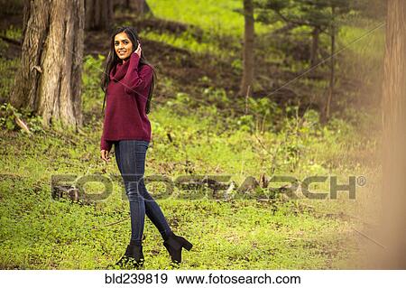 Stock Photo - Smiling Indian woman posing in forest. Fotosearch