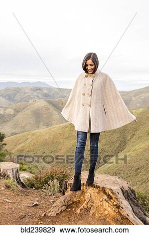 Smiling Indian woman wearing poncho standing on tree stump View Large Photo Image Stock Photo - Smiling Indian woman wearing poncho standing on tree stump. Fotosearch