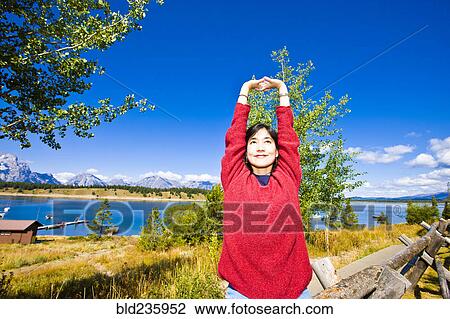 Smiling Japanese woman stretching arms near lake View Large Photo Image Stock Image - Smiling Japanese woman stretching arms near lake. Fotosearch