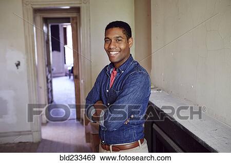 Stock Photo - Smiling man posing in empty house. Fotosearch