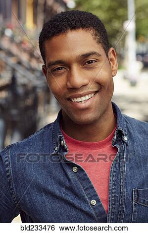 Stock Photograph - Smiling man posing on city sidewalk. Fotosearch