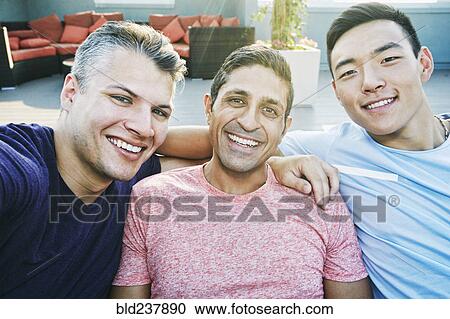 Stock Image - Smiling men posing on rooftop. Fotosearch