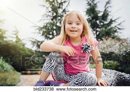 Smiling Mixed Race girl sitting on bench View Large Photo Image Stock Photo - Smiling Mixed Race girl sitting on bench. Fotosearch