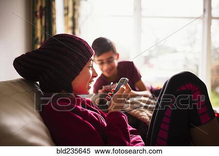 Stock Photography - Smiling Mixed Race using cell phone. Fotosearch