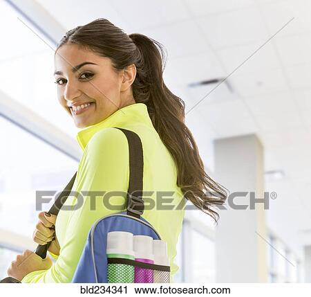 Smiling Mixed Race woman carrying bag at gymnasium View Large Photo Image Stock Image - Smiling Mixed Race woman carrying bag at gymnasium. Fotosearch