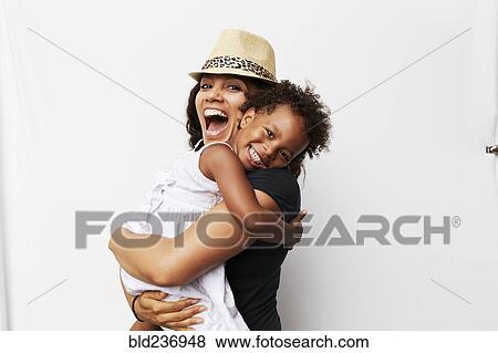 Smiling Mixed Race woman hugging daughter View Large Photo Image Stock Photo - Smiling Mixed Race woman hugging daughter. Fotosearch