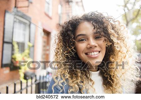 Smiling Mixed Race woman in city View Large Photo Image Stock Image - Smiling Mixed Race woman in city. Fotosearch