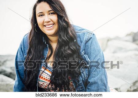 Smiling Mixed Race woman near ocean View Large Photo Image Stock Photograph - Smiling Mixed Race woman near ocean. Fotosearch